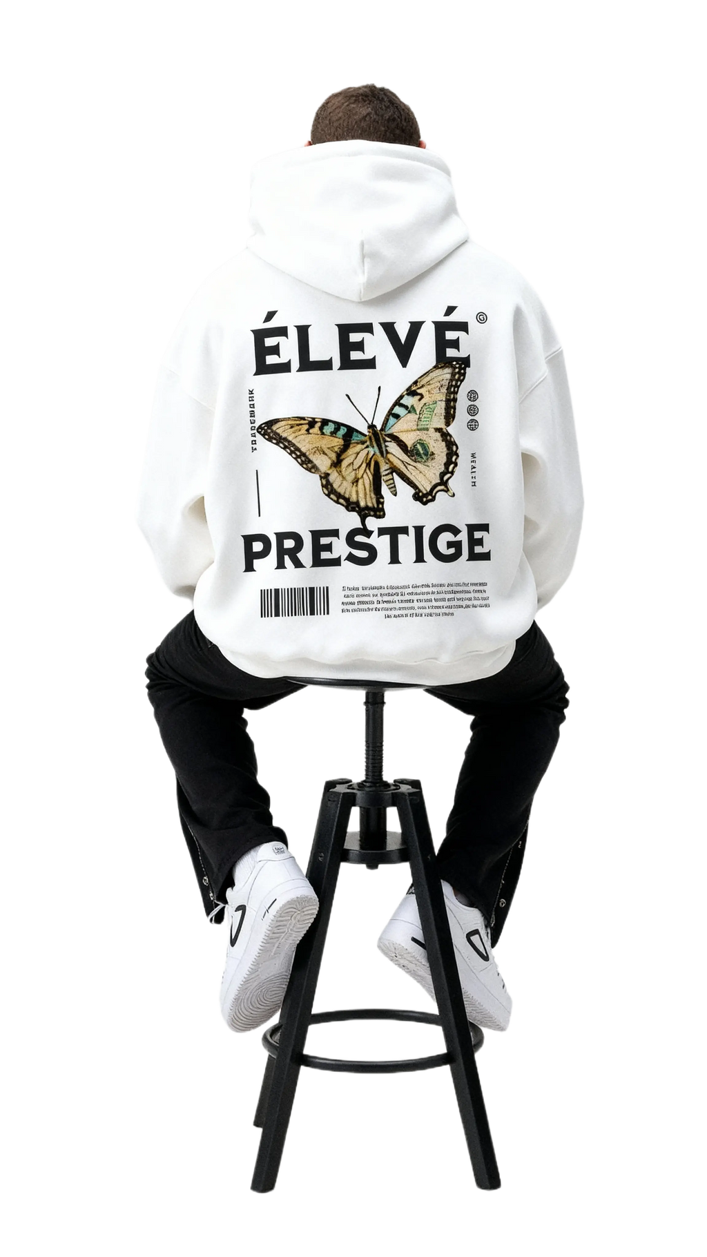 ÉLEVÉ Prestige Hoodie White mit großem Butterfly Backprint, Model sitzend auf Hocker – weißer Premium Unisex Streetwear Hoodie aus dem Prestige Drop